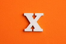 White Wooden Capital Letter X On Orange Foamy Background