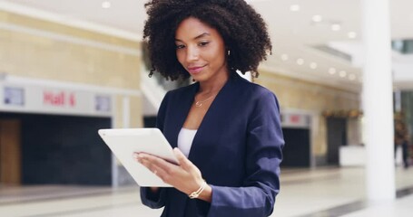 Canvas Print - She's always connected and ready. Businesswoman using a digital tablet in the workplace. Beautiful young African female with an afro checking her emails , looking happy and relaxed at work 