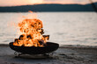 Brenndes Feuer in einer Feuerschale am See 