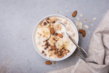 Wall Mural - Healthy breakfast of granola with fresh banana, nuts and yogurt