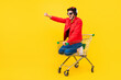 Leinwandbild Motiv Full length body size view of attractive cheery guy inside cart having fun riding fooling isolated on bright yellow color background