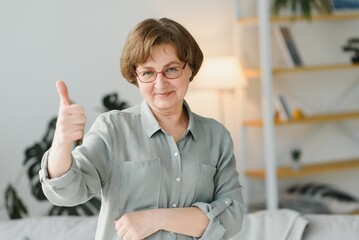 Canvas Print - Women senior hands show class doing funky action gray hair woman, middle aged smile old woman wearing glasses at home, positive lonely senior pensioner happiness woman.