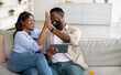 Leinwandbild Motiv Happy black couple using tablet, celebrating win giving high five