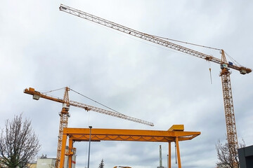 Canvas Print - Low angle shot of cranes in the construction site