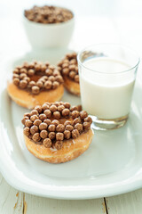 Wall Mural - Vertical shot of chocolate cereal donuts and a cup of milk