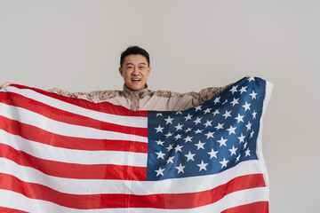 Wall Mural - Asian military man smiling while posing with american flag