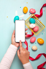 Poster - Vertical top view of a blank screen for copy space in hands over colorful Easter eggs