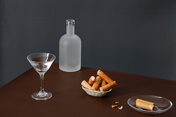 Wall Mural - Beautiful shot of creamy wafers and a bottle of an alcoholic drink with a glass and a glass teacup