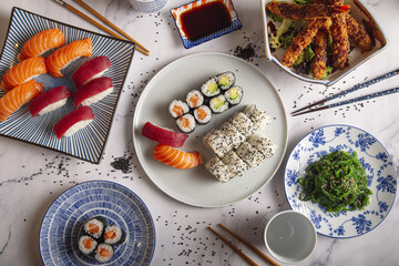 Poster - Set of various sushi rolls, prawn tempura, wakame seaweed salad, soy sauce and chopsticks on a table