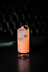 Poster - Beautiful shot of an orange cocktail on a black background