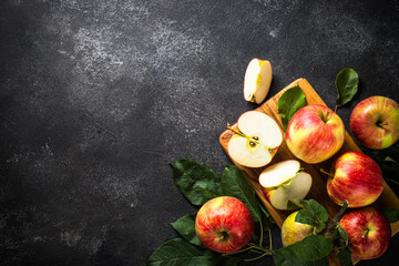 Wall Mural - Fresh ripe apples, whole and sliced apples at black stone table. Top view with copy space.