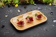 Appetizer from dry cured ham, prosciutto slices on a dark background. Photo for restaurant menu
