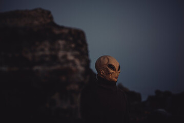 Portrait of alien head in a dark outdoors nature background. Concept of aliens among us. Extraterrestrial life. Creepy horror concept image. Life on earth and another planet discover science