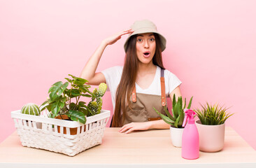 Wall Mural - hispanic pretty woman looking happy, astonished and surprised. plants and gardering concept