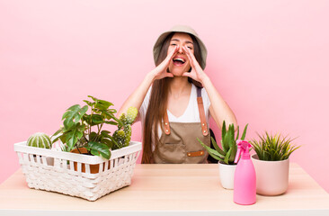 Wall Mural - hispanic pretty woman feeling happy,giving a big shout out with hands next to mouth. plants and gardering concept