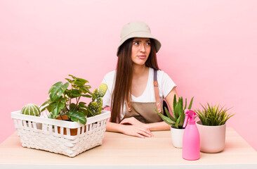 Wall Mural - hispanic pretty woman feeling sad, upset or angry and looking to the side. plants and gardering concept