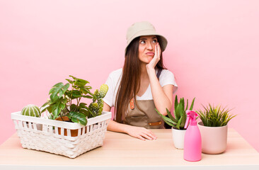 Wall Mural - hispanic pretty woman feeling bored, frustrated and sleepy after a tiresome. plants and gardering concept