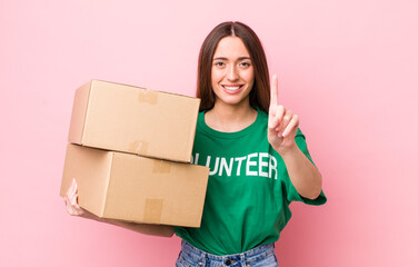 Poster - hispanic pretty woman smiling and looking friendly, showing number one. volunteer concept