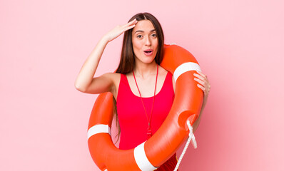 Wall Mural - hispanic pretty woman looking happy, astonished and surprised. lifeguard concept