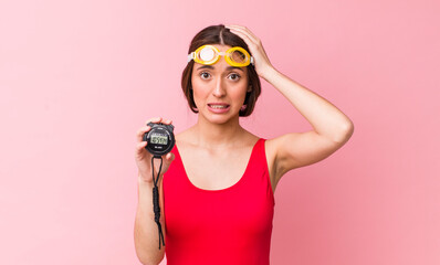 Poster - hispanic pretty woman feeling stressed, anxious or scared, with hands on head. swimmer and timer concept