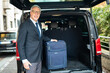 © Minerva Studio - Senior porter smiling near his car with baggage inside