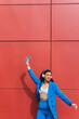 © Dani D.G - Funny and cheerful black woman dressed in blue, Dancing while listening to music. Fashion portrait of hipster african girl with funny curly hairstyle, modern urban style of 90s. Vertical copy space.