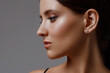 Close-up profile of a caucasian girl with perfect young fresh skin on a gray background. Facial care and face profile correction