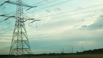high-voltage power transmission lines stretch along road. grid tower built in countryside against cl