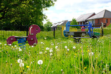 Exeter, UK/ May 2020: A Childrens Park Has Been Closed Down To Users Due To The Lockdown Measures For Coronavirus, Covid-19 And The Grass Is Now Overgrown