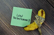 Low Testoterone write on sticky notes and Banana isolated on Wooden Table.