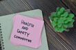 © syahrir - Health and Safety Committee write on sticky notes isolated on Wooden Table.