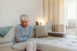 © Jelena Stanojkovic - Mature woman suffering from stomach ache sitting on a bed in the bedroom. Photo of mature adult woman sitting on her bed has a stomach ache in the bedroom. Senior woman suffering from stomach pain