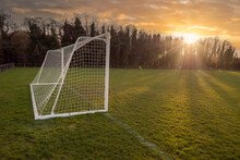 Football Or Soccer Goal Post On A Training Ground In A Park At Sunset. Warm Color. Sun Flare. Nobody. Outdoor Activity. Calm Nature Background