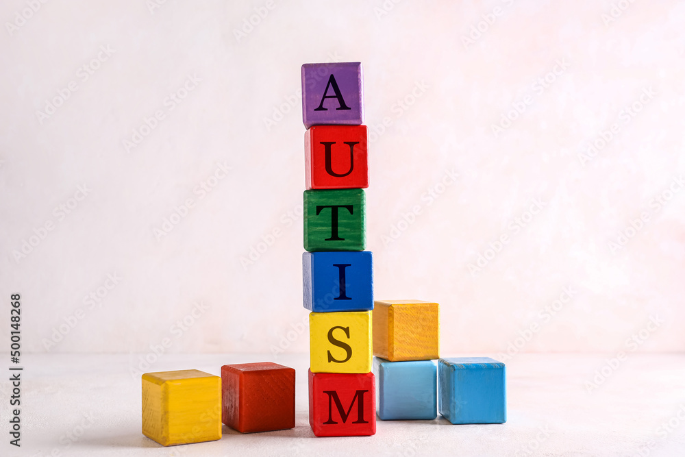 Cubes with word AUTISM on white background