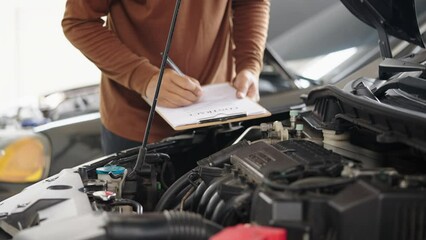 Wall Mural - Photo of car mechanic repairs a car engine in his repair shop.