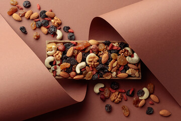 The mix of dried fruits and berries on a brown background.