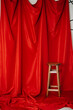 Background for photo studio with red fabric and chair