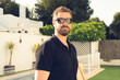 © Danko - Hipster handsome male model with beard wearing black polo shirt with space for your logo or design in casual urban style