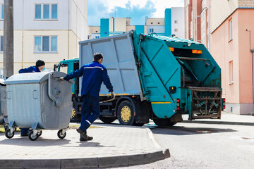 An automobile garbage truck collects garbage in residential areas of a modern city. Close-up of a car for collecting and transporting garbage.