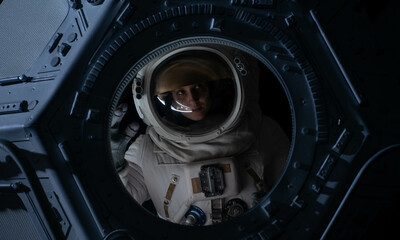 Wall Mural - portrait of caucasian female astronaut flying towards spaceship cupola window. space exploration, ma