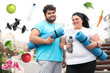 © New Africa - Weight loss concept. Overweight couple in sportswear with mats outdoors