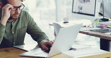 Aufkleber - This is a tough one. 4k video footage of a tired young businessman working on his laptop in the office.