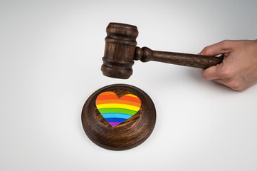 The judge hits a heart with a rainbow flag with a gavel.