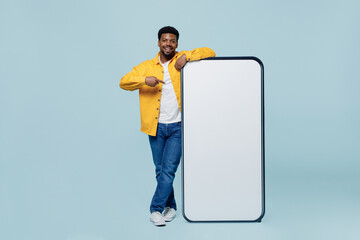 full body smiling man of african american ethnicity wear yellow shirt point finger on big blank scre