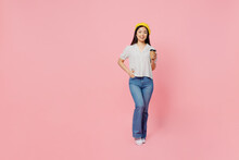 Full Body Smiling Fun Young Woman Of Asian Ethnicity 20s Wear White Polka Dot T-shirt Yellow Beret Hold Takeaway Delivery Craft Paper Brown Cup Coffee To Go Isolated On Plain Pastel Pink Background