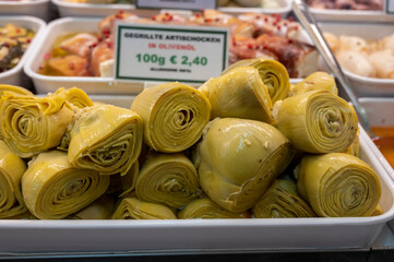 Wall Mural - Pickled and grilled heads of fresh organic artichoke flowers, edible vegetables green artichokes, English translation is Grilled artishokes in olive oil