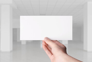 hand holding blank voucher  hall background