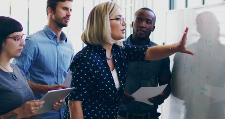 Canvas Print - Bringing their ideas to life. 4K video footage of a diverse group colleagues brainstorming together on a whiteboard in a modern office.