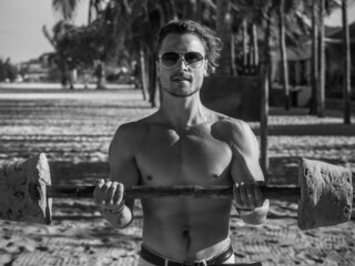 Black and white picture of fitness man working out on the beach