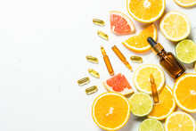 Vitamin C. Anti Aging Cosmetic. Fresh Citrus Fruits With Serum Bottles, Ampoules And Pills. Top View With Copy Space.